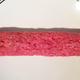 Pink cylinder of raw meat extruded from Sushi Bazooka, fully encasing the Big Mac ingredients